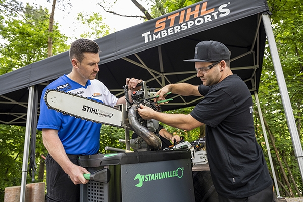 Timbersports Athlet Thomas Hofbauer (l.) prüft seine Hot Saw - die Techniker unterstützen mit Stahlwille Werkzeug. 